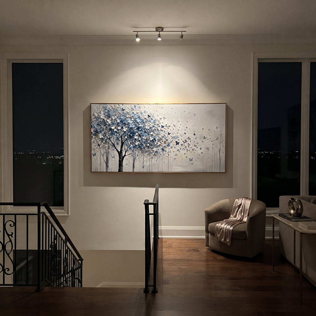 "Blue Butterfly Tree Painting" focuses on atmosphere, surface movement, and sculptural heavy impasto craftsmanship rather than a fixed literal storyline. The composition uses this hand-painted panoramic canvas presents a blue grey and white blossoming tree on the left with small blue butterflies drifting into an open white textured field as the visual anchor, while layered palette-knife paint, raised plaster-like texture, and softened brush movement create tactile depth across the canvas.