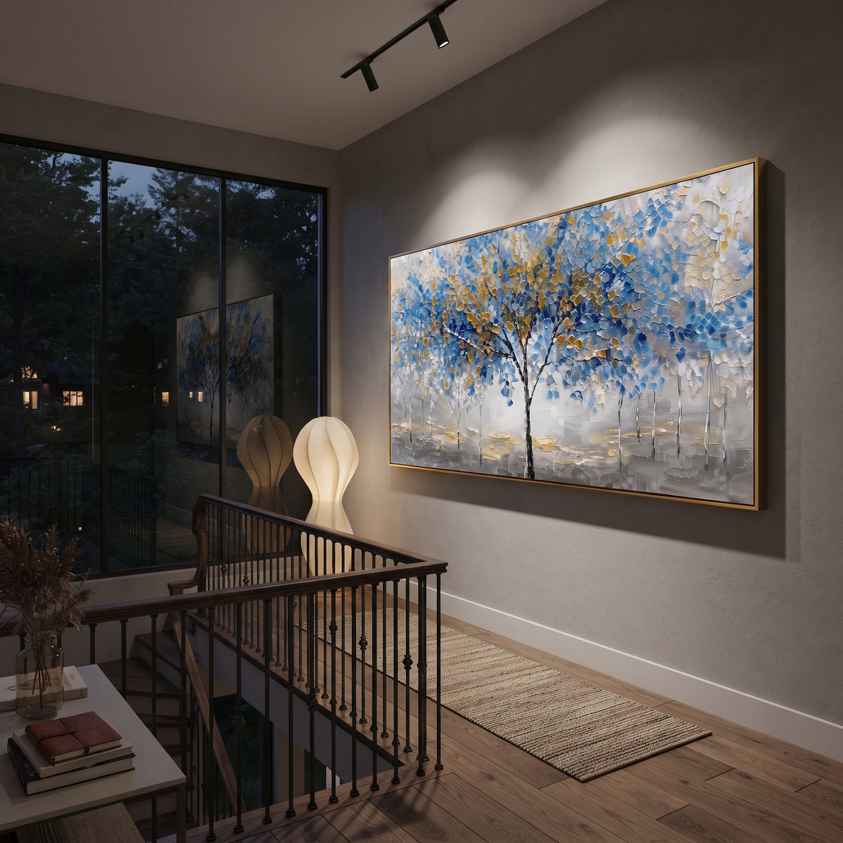 "Blue Gold Tree Painting" focuses on atmosphere, surface movement, and sculptural heavy impasto craftsmanship rather than a fixed literal storyline. The composition uses this hand-painted panoramic canvas presents a central black tree with blue and golden leaves over a grey white textured ground, with slender pale trees in the background as the visual anchor, while layered palette-knife paint, raised plaster-like texture, and softened brush movement create tactile depth across the canvas.