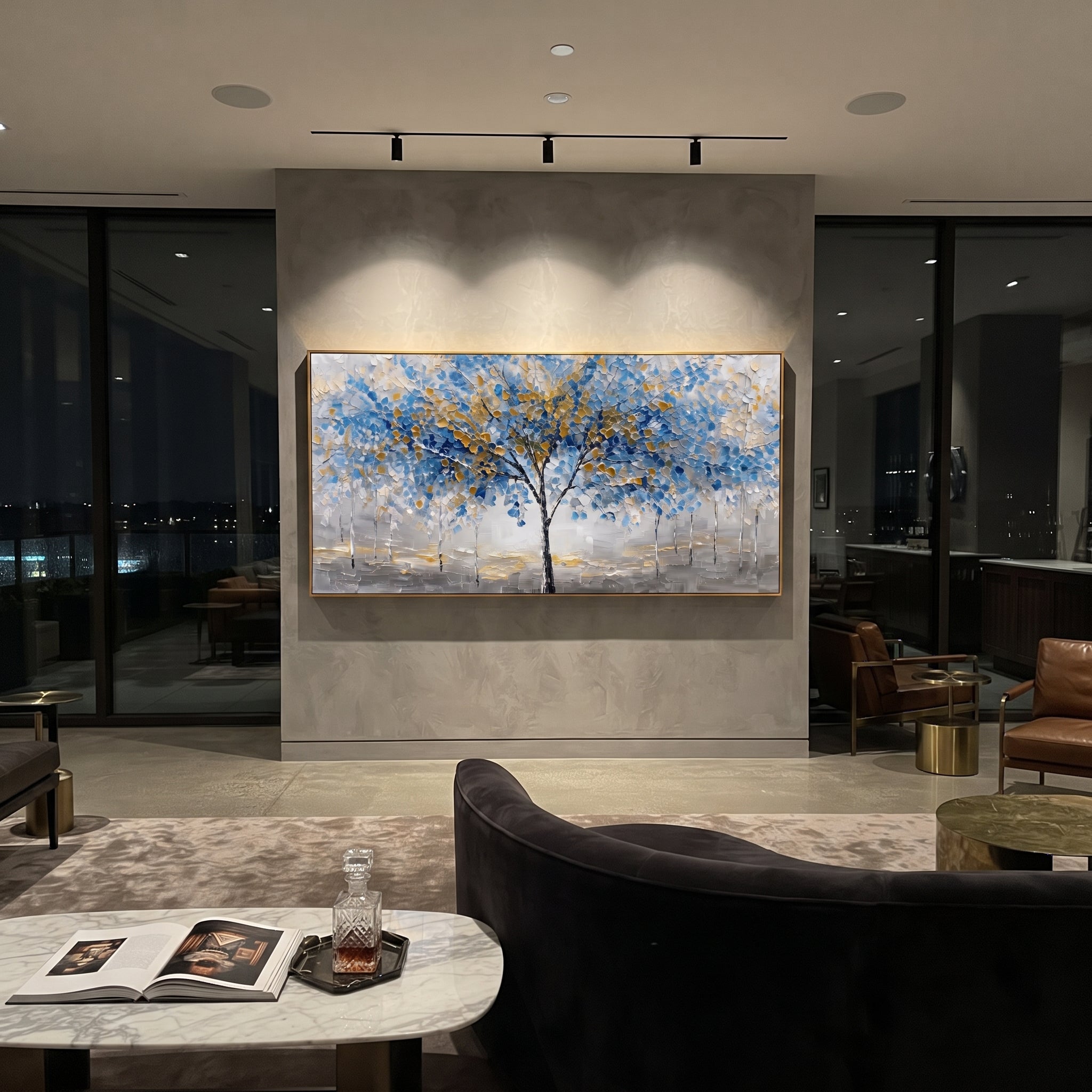 "Blue Gold Tree Painting" focuses on atmosphere, surface movement, and sculptural heavy impasto craftsmanship rather than a fixed literal storyline. The composition uses this hand-painted panoramic canvas presents a central black tree with blue and golden leaves over a grey white textured ground, with slender pale trees in the background as the visual anchor, while layered palette-knife paint, raised plaster-like texture, and softened brush movement create tactile depth across the canvas.