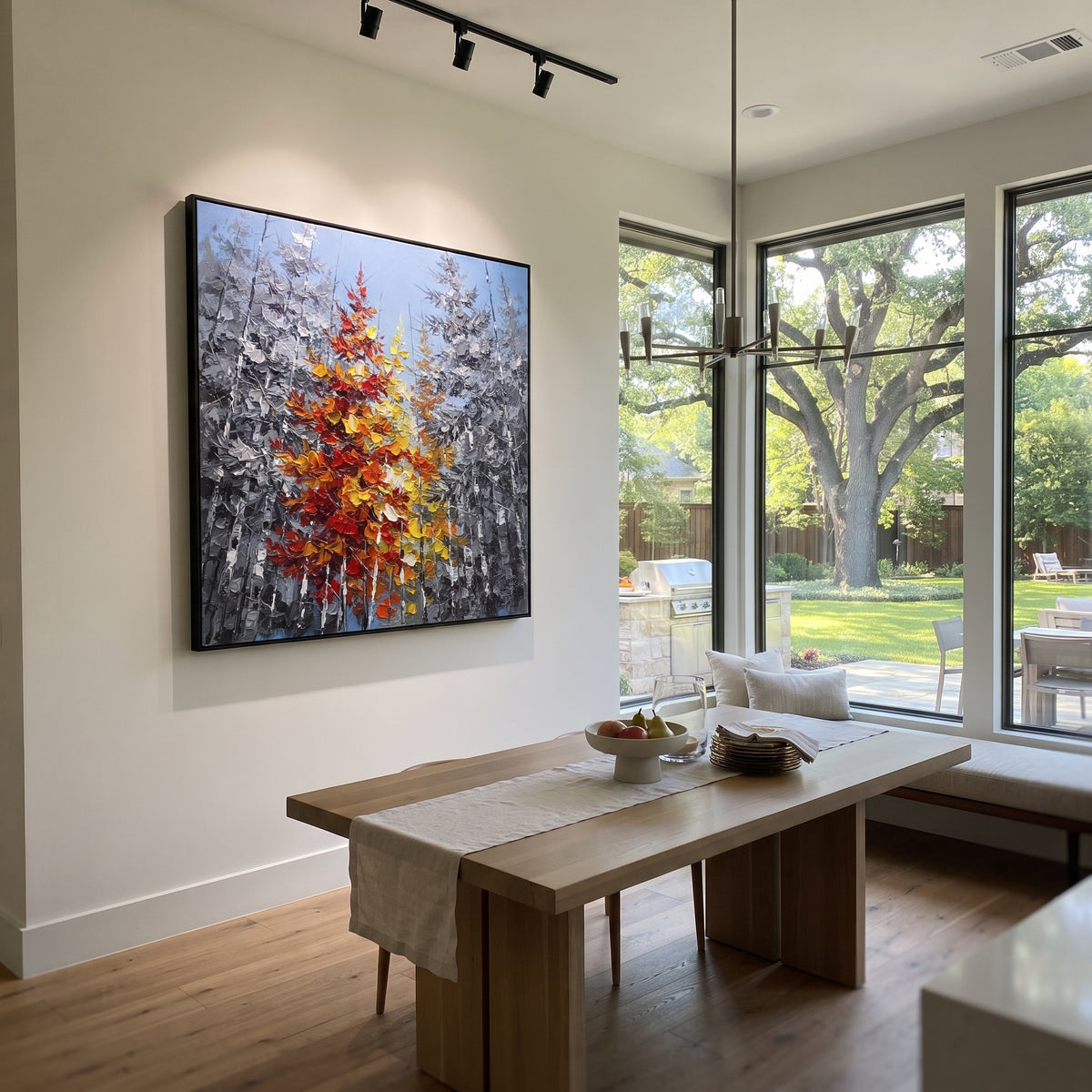 "Red Maple Birch Grove Painting" focuses on atmosphere, surface movement, and sculptural heavy impasto craftsmanship rather than a fixed literal storyline. The composition uses this hand-painted square canvas presents a blue grey birch grove with tall dark trunks and a central cluster of red, orange, yellow, and cream autumn foliage shaped in thick palette-knife texture as the visual anchor, while layered palette-knife paint, raised plaster-like texture, and softened brush movement create