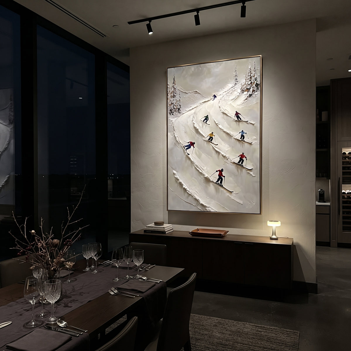 Highland Pine Slope focuses on layered snow ridges, visible ski marks, and a quiet pine border. The artwork shows a winter ski scene built from the actual image: visible downhill figures, curved snow tracks, raised ridgelines, and alpine space arranged in a tall composition. The white, black, gray palette gives the piece a cold mountain atmosphere while the thick impasto surface creates shadows along each snowbank, ski line, and textured ridge. This is presented as hand-painted textured canvas