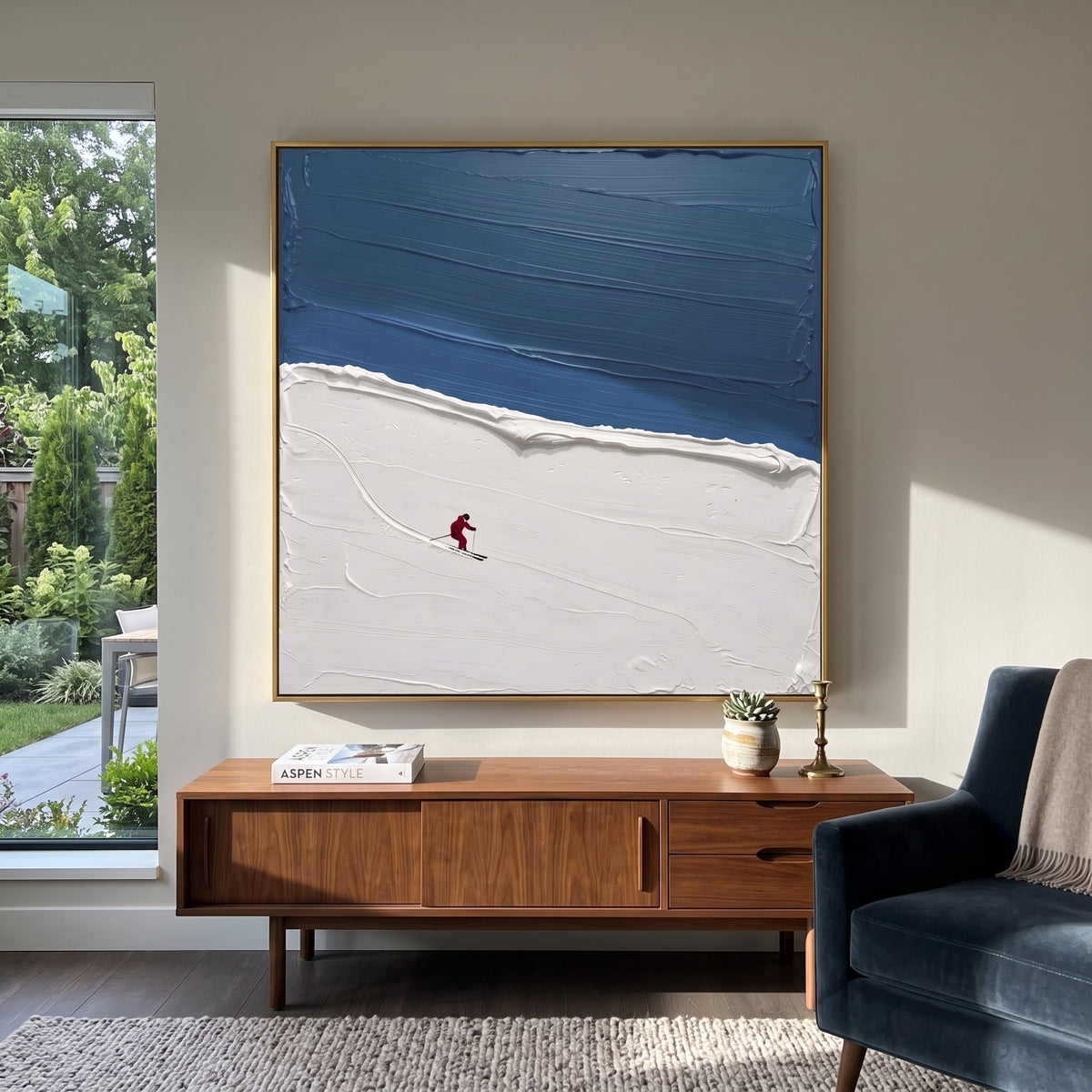 Blue Ridge Solo Skier focuses on one red skier crossing a quiet blue ridge below a deep winter sky. The artwork shows a winter ski scene built from the actual image: visible downhill figures, curved snow tracks, raised ridgelines, and alpine space arranged in a balanced composition. The blue, white, red palette gives the piece a cold mountain atmosphere while the thick impasto surface creates shadows along each snowbank, ski line, and textured ridge. This is presented as hand-painted textured