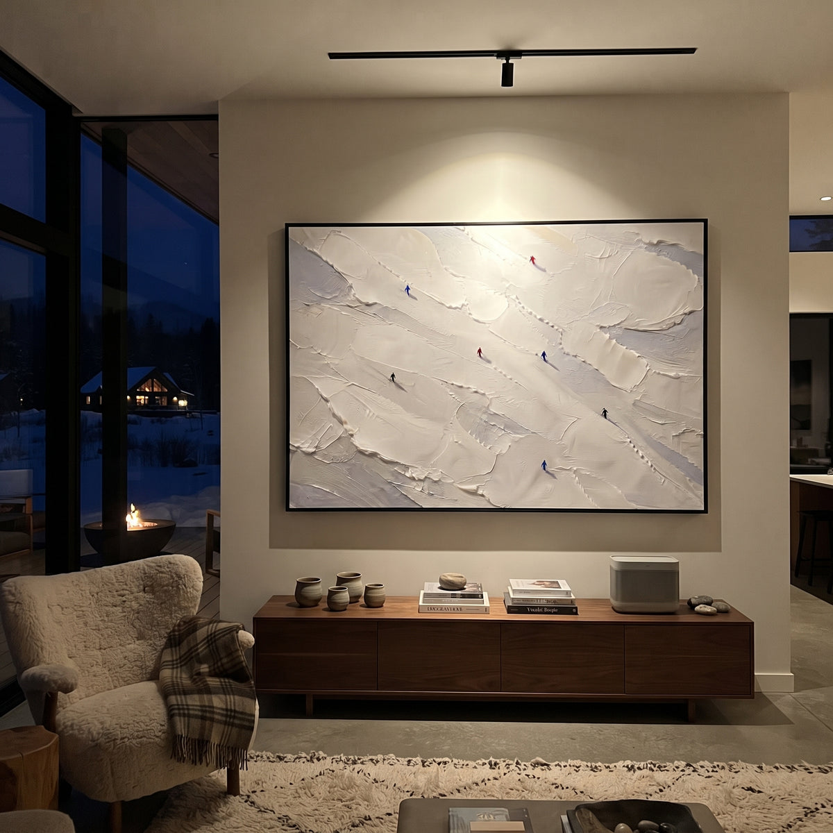 Frosted Pine Slope With Pine Shadows focuses on layered snow ridges, visible ski marks, and a quiet pine border. The artwork shows a winter ski scene built from the actual image: visible downhill figures, curved snow tracks, raised ridgelines, and alpine space arranged in a wide composition. The blue, white, orange palette gives the piece a cold mountain atmosphere while the thick impasto surface creates shadows along each snowbank, ski line, and textured ridge. This is presented as hand-painted