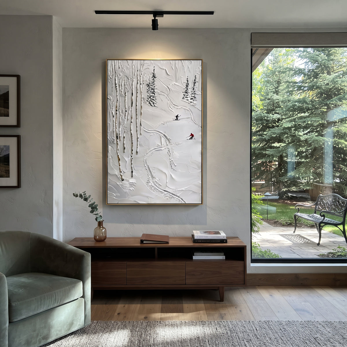 Carved Texture Run focuses on layered snow ridges, visible ski marks, and a quiet pine border. The artwork shows a winter ski scene built from the actual image: visible downhill figures, curved snow tracks, raised ridgelines, and alpine space arranged in a tall composition. The blue, white, orange palette gives the piece a cold mountain atmosphere while the thick impasto surface creates shadows along each snowbank, ski line, and textured ridge. This is presented as hand-painted textured canvas