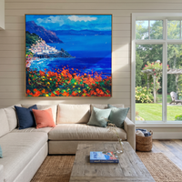 This 100% hand-painted coastal landscape features this hand-painted square canvas captures a bright Mediterranean coastal village with white cliffside buildings, deep blue sea, distant mountain forms, and vivid orange-green foreground flowers. Thick palette-knife strokes and saturated color give the seaside landscape a sunny, expressive presence for living rooms, dining areas, bedrooms, offices, and vacation-inspired interiors.