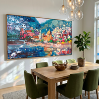 This 100% hand-painted coastal landscape features turquoise water, a pastel village, and lively reflections built with expressive palette-knife texture. Its wide horizontal shape works beautifully above sofas, dining tables, consoles, and hospitality feature walls.