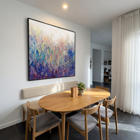 This 100% hand-painted floral abstract landscape uses heavy palette-knife texture to create the feeling of wild grasses and blooming flowers moving in the light. Violet, blue, pink, and soft neutral tones give the piece a romantic but modern atmosphere.