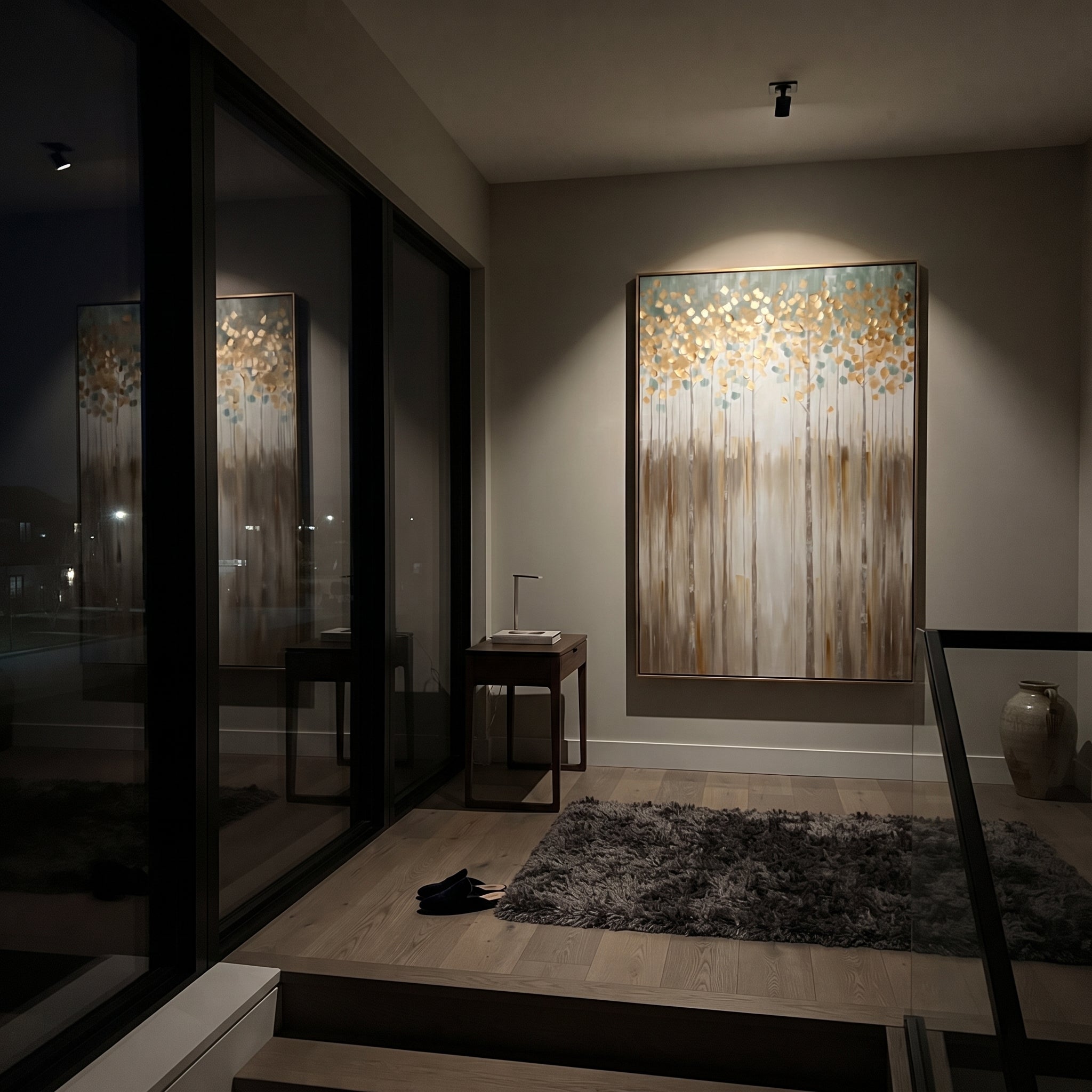"Gold Blue Vertical Forest Painting" focuses on atmosphere, surface movement, and sculptural heavy impasto craftsmanship rather than a fixed literal storyline. The composition uses this hand-painted vertical canvas presents a tall vertical forest with slim trunks, golden round leaves, blue-green haze, and warm beige lower strokes, with visible raised palette-knife texture and handmade surface depth as the visual anchor, while layered palette-knife paint, raised plaster-like texture, and softened
