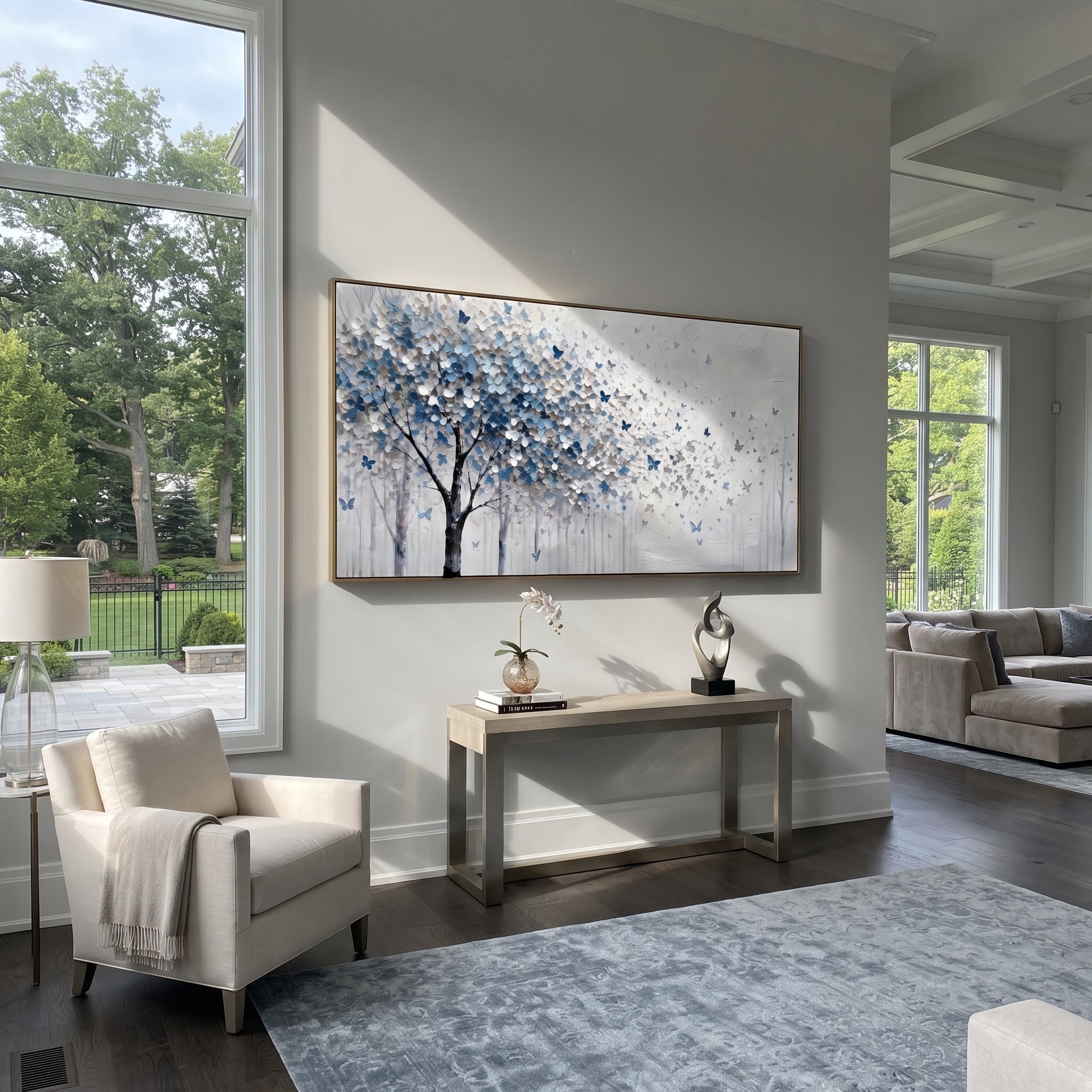 "Blue Butterfly Tree Painting" focuses on atmosphere, surface movement, and sculptural heavy impasto craftsmanship rather than a fixed literal storyline. The composition uses this hand-painted panoramic canvas presents a blue grey and white blossoming tree on the left with small blue butterflies drifting into an open white textured field as the visual anchor, while layered palette-knife paint, raised plaster-like texture, and softened brush movement create tactile depth across the canvas.