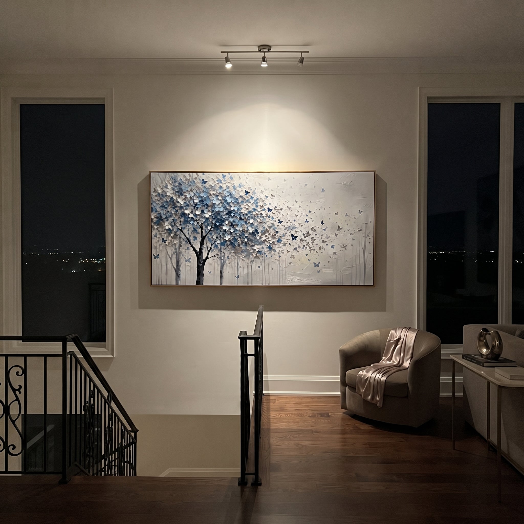"Blue Butterfly Tree Painting" focuses on atmosphere, surface movement, and sculptural heavy impasto craftsmanship rather than a fixed literal storyline. The composition uses this hand-painted panoramic canvas presents a blue grey and white blossoming tree on the left with small blue butterflies drifting into an open white textured field as the visual anchor, while layered palette-knife paint, raised plaster-like texture, and softened brush movement create tactile depth across the canvas.
