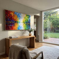 "Colorful Lake Reflection Painting" focuses on atmosphere, surface movement, and sculptural heavy impasto craftsmanship rather than a fixed literal storyline. The composition uses this hand-painted panoramic canvas presents a bright lake reflection scene with red orange trees on the left, green trees on the right, blue water, and a white glowing center as the visual anchor, while layered palette-knife paint, raised plaster-like texture, and softened brush movement create tactile depth across the