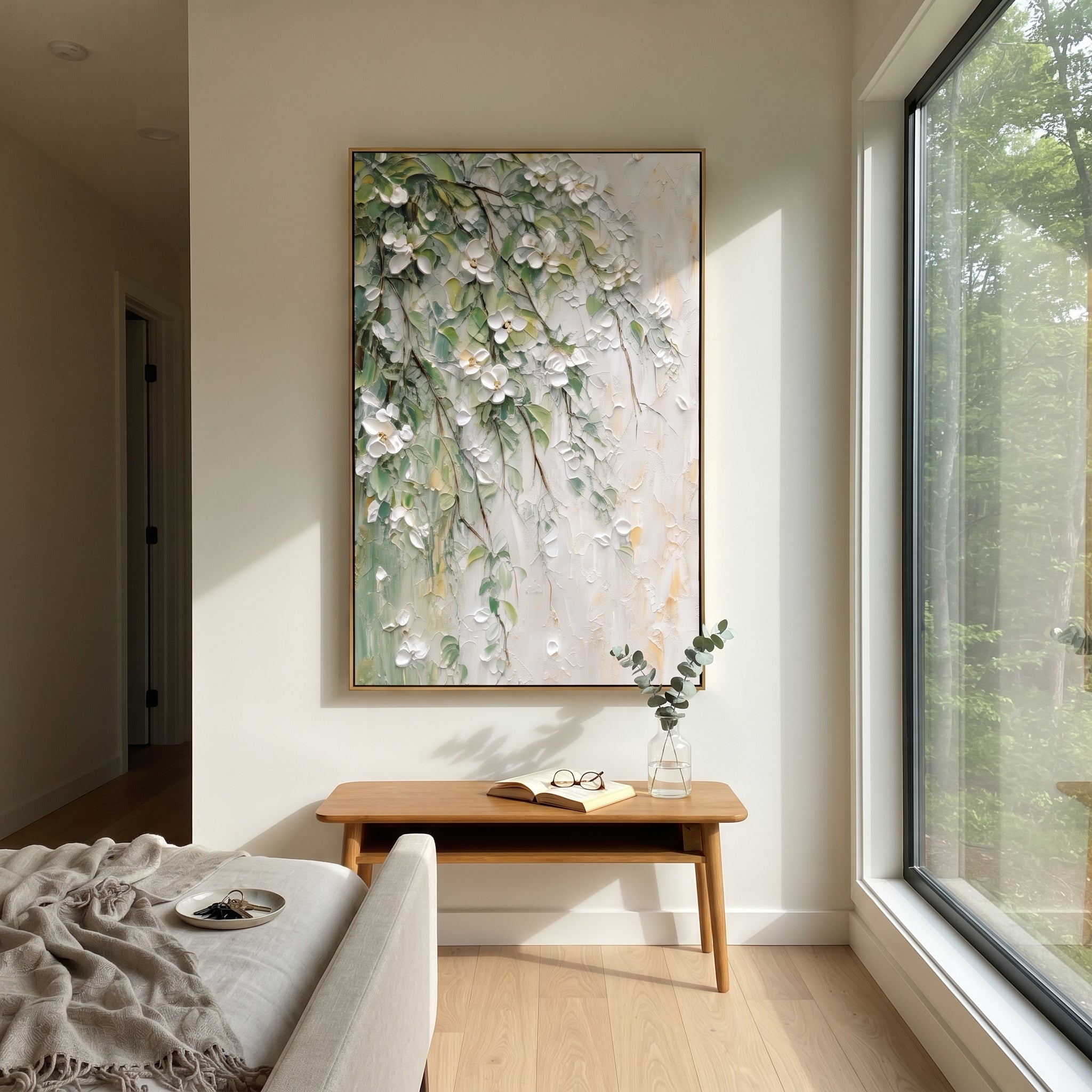 "White Green Floral Branch Painting" focuses on atmosphere, surface movement, and sculptural heavy impasto craftsmanship rather than a fixed literal storyline. The composition uses this hand-painted vertical canvas presents white raised blossoms and green leaves trailing diagonally over a pale textured wall, with thin brown branches and soft gold touches as the visual anchor, while layered palette-knife paint, raised plaster-like texture, and softened brush movement create tactile depth across