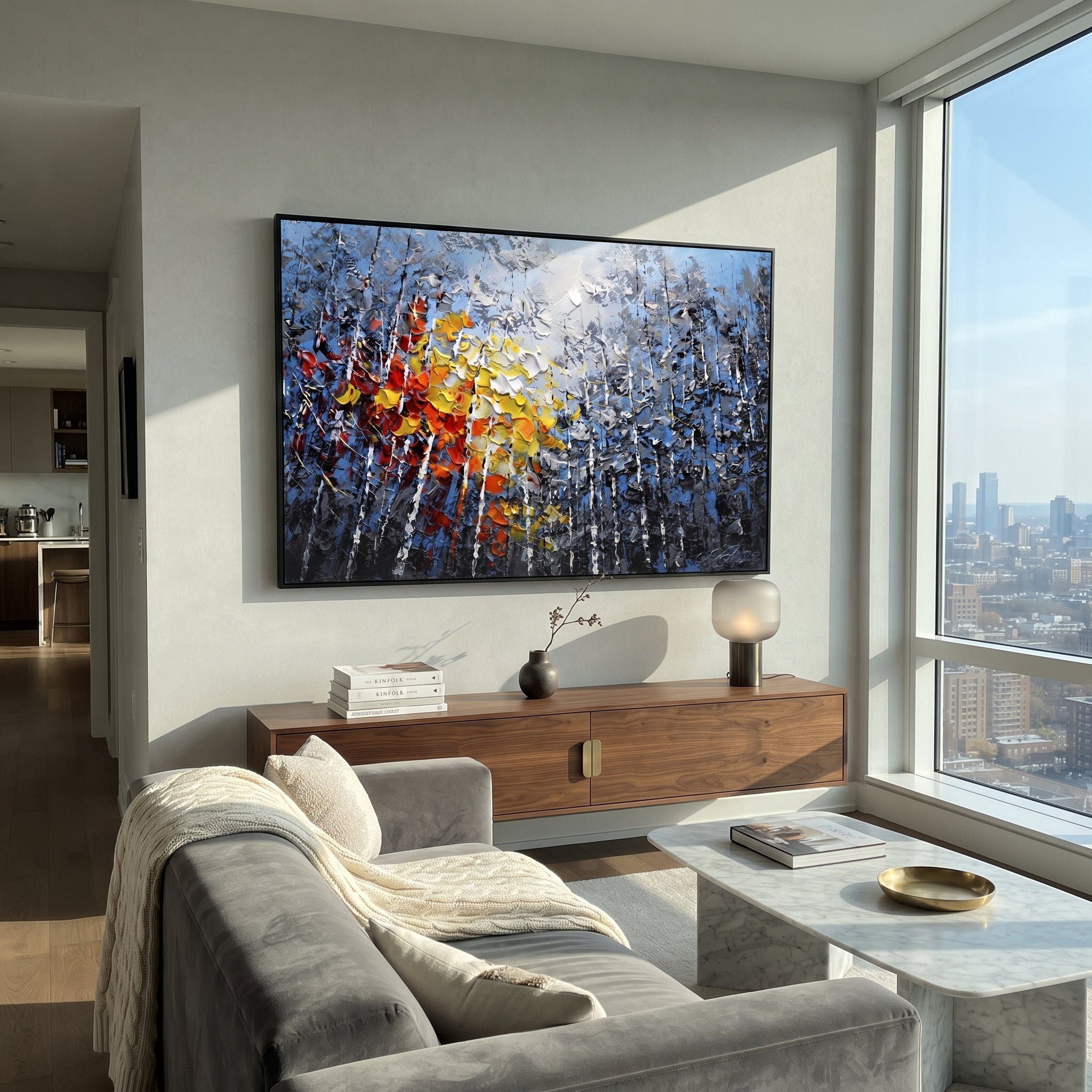 "Blue Birch Autumn Glow Painting" focuses on atmosphere, surface movement, and sculptural heavy impasto craftsmanship rather than a fixed literal storyline. The composition uses this hand-painted horizontal canvas presents blue grey birch woods with white vertical trunks, smoky foliage, and thick red, orange, yellow, and white palette-knife leaves glowing through the center as the visual anchor, while layered palette-knife paint, raised plaster-like texture, and softened brush movement create