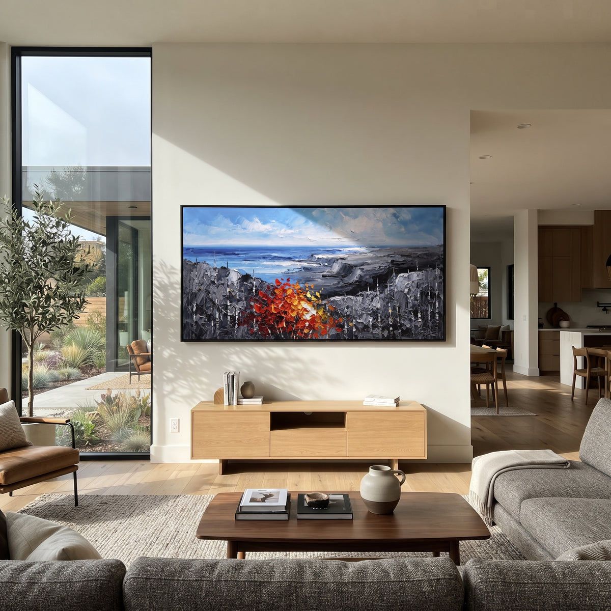 "Blue Coast Autumn Painting" focuses on atmosphere, surface movement, and sculptural heavy impasto craftsmanship rather than a fixed literal storyline. The composition uses this hand-painted panoramic canvas shows an open blue shoreline and grey rocky headlands, anchored by a thick red orange autumn tree and dark textured woodland in the foreground as the visual anchor, while layered palette-knife paint, raised plaster-like texture, and softened brush movement create tactile depth across the