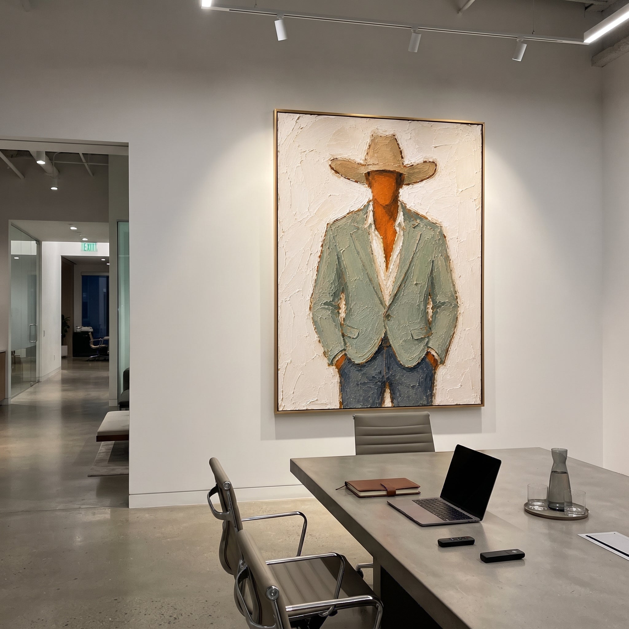 "Buttoned Sage Cowboy Painting" focuses on atmosphere, surface movement, and sculptural heavy impasto craftsmanship rather than a fixed literal storyline. The composition uses this hand-painted vertical canvas presents a centered cowboy in a buttoned pale sage blazer, cream shirt, tan hat, and muted blue trousers as the visual anchor, while layered palette-knife paint, raised plaster-like texture, and softened brush movement create tactile depth across the canvas. Curated with a balanced green