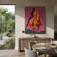 "Front Riding Pink Horse Painting" focuses on atmosphere, surface movement, and sculptural heavy impasto craftsmanship rather than a fixed literal storyline. The composition uses this hand-painted vertical canvas features a cowboy riding a golden brown horse toward the viewer, set against a textured pink wall with dark teal shadow strokes as the visual anchor, while layered palette-knife paint, raised plaster-like texture, and softened brush movement create tactile depth across the canvas.