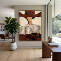 "Cropped Brown Hat Cowboy Painting" focuses on atmosphere, surface movement, and sculptural heavy impasto craftsmanship rather than a fixed literal storyline. The composition uses this hand-painted vertical canvas presents a cropped western portrait with a broad brown hat shadowing a faceless head above a white black-striped shirt as the visual anchor, while layered palette-knife paint, raised plaster-like texture, and softened brush movement create tactile depth across the canvas. Curated with