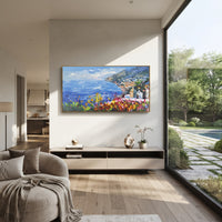"Cliff Harbor Houses Painting" focuses on atmosphere, surface movement, and sculptural heavy impasto craftsmanship rather than a fixed literal storyline. The composition uses this hand-painted Mediterranean canvas features stacked pastel buildings on seaside cliffs, boats below, bright impasto coastal color, built with raised palette-knife texture, layered brushwork, and luminous coastal color as the visual anchor, while layered palette-knife paint, raised plaster-like texture, and softened