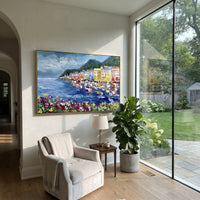 "Flowered Cliff Vista Study Painting" focuses on atmosphere, surface movement, and sculptural heavy impasto craftsmanship rather than a fixed literal storyline. The composition uses this hand-painted Mediterranean canvas features steep coastal cliffs, hillside village, deep blue water, floral foreground, textured sky, built with raised palette-knife texture, layered brushwork, and luminous coastal color as the visual anchor, while layered palette-knife paint, raised plaster-like texture, and