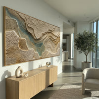 This topographic plaster relief painting uses raised earth-toned plates, carved contour lines, and muted teal passages to suggest a terrain map or river valley. Its panoramic format gives the sculptural abstract surface a wide architectural presence.