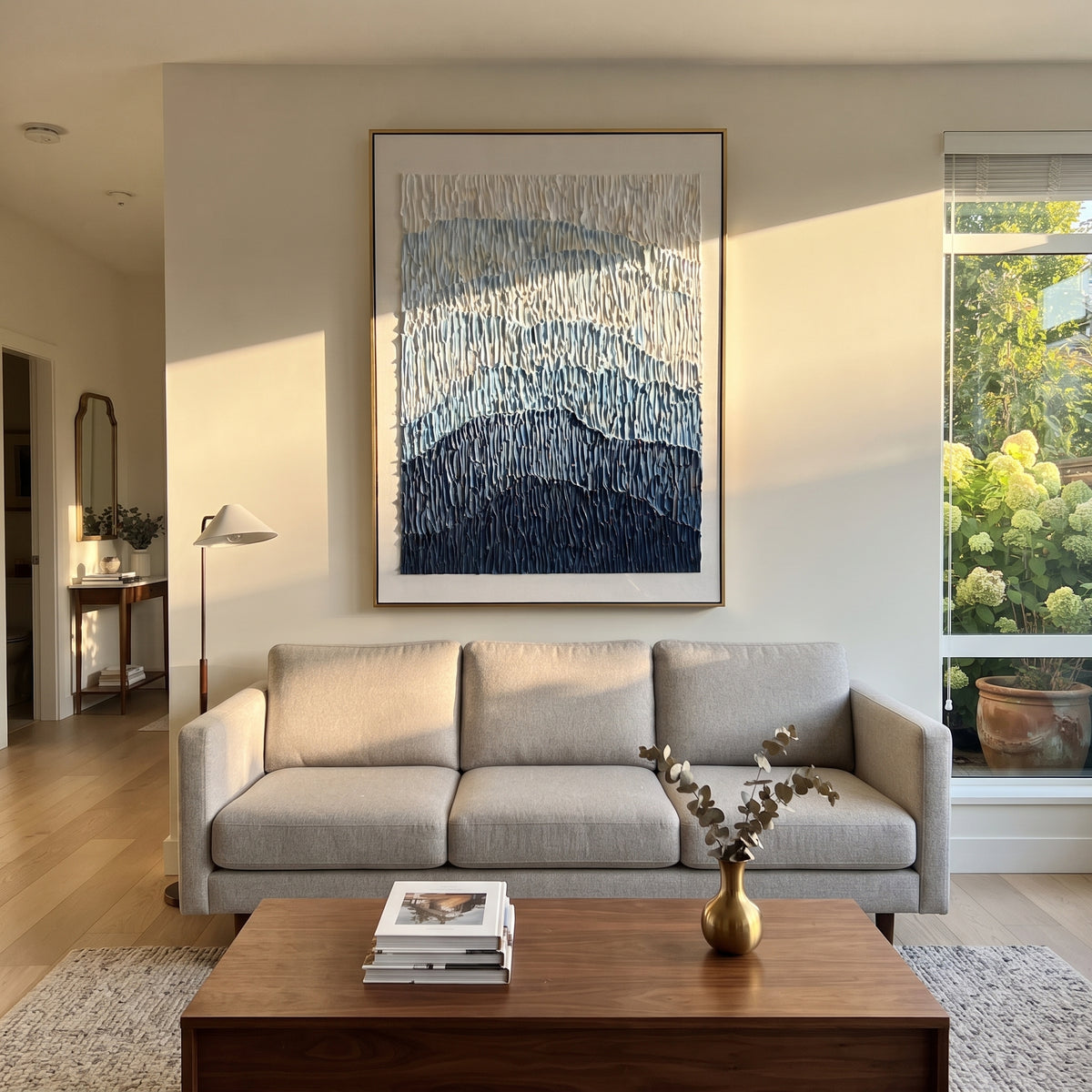 This blue mountain gradient relief painting uses stacked blue bands and vertical combed plaster texture to suggest distant mountains, glaciers, or rolling terrain. Its restrained blue-white palette gives the vertical canvas a calm architectural presence.