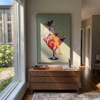 Cowboy Martini Chair focuses on a western figure sitting in a martini-shaped chair with bold red and gold accents, using the sage green family as the main atmosphere while keeping the subject and composition specific to the actual main image. The visible details are described from the artwork itself: the placement of the main forms, the surrounding negative space, the relationship between pale highlights and deeper green or dark accents, and the direction of the brushwork across the surface.