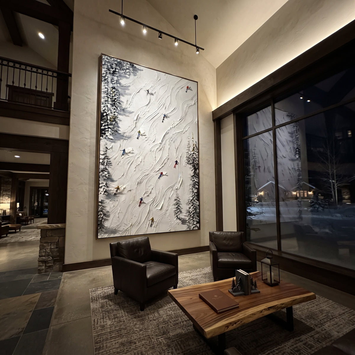 Silver Mountain Run focuses on a calm mountain basin with crisp tracks, snow shelves, and small skiers. The artwork shows a winter ski scene built from the actual image: visible downhill figures, curved snow tracks, raised ridgelines, and alpine space arranged in a tall composition. The white, gray, blue palette gives the piece a cold mountain atmosphere while the thick impasto surface creates shadows along each snowbank, ski line, and textured ridge. This is presented as hand-painted textured