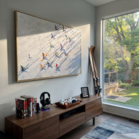 Winter Alpine Descent With Pine Shadows focuses on a broad winter slope filled with curved ski trails and miniature moving figures. The artwork shows a winter ski scene built from the actual image: visible downhill figures, curved snow tracks, raised ridgelines, and alpine space arranged in a wide composition. The white, beige, blue palette gives the piece a cold mountain atmosphere while the thick impasto surface creates shadows along each snowbank, ski line, and textured ridge. This is
