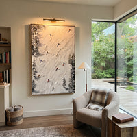 Fresh Ski Traverse focuses on layered snow ridges, visible ski marks, and a quiet pine border. The artwork shows a winter ski scene built from the actual image: visible downhill figures, curved snow tracks, raised ridgelines, and alpine space arranged in a tall composition. The blue, white, orange palette gives the piece a cold mountain atmosphere while the thick impasto surface creates shadows along each snowbank, ski line, and textured ridge. This is presented as hand-painted textured canvas