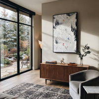 Pine Texture Run focuses on a calm mountain basin with crisp tracks, snow shelves, and small skiers. The artwork shows a winter ski scene built from the actual image: visible downhill figures, curved snow tracks, raised ridgelines, and alpine space arranged in a tall composition. The white, black, gray palette gives the piece a cold mountain atmosphere while the thick impasto surface creates shadows along each snowbank, ski line, and textured ridge. This is presented as hand-painted textured