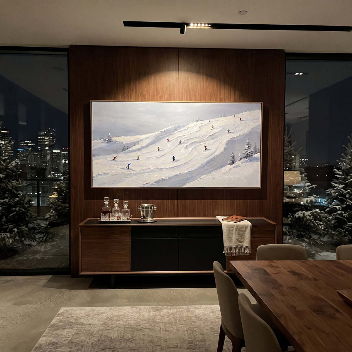 Ice Ski Tracks With Pine Shadows focuses on a forest-framed ski descent with clustered pines and winding carved tracks. The artwork shows a winter ski scene built from the actual image: visible downhill figures, curved snow tracks, raised ridgelines, and alpine space arranged in a wide composition. The white, beige, blue palette gives the piece a cold mountain atmosphere while the thick impasto surface creates shadows along each snowbank, ski line, and textured ridge. This is presented as