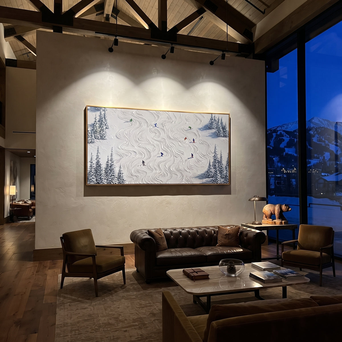 Resort Mountain Run With Blue Tracks focuses on a calm mountain basin with crisp tracks, snow shelves, and small skiers. The artwork shows a winter ski scene built from the actual image: visible downhill figures, curved snow tracks, raised ridgelines, and alpine space arranged in a wide composition. The blue, white, orange palette gives the piece a cold mountain atmosphere while the thick impasto surface creates shadows along each snowbank, ski line, and textured ridge. This is presented as