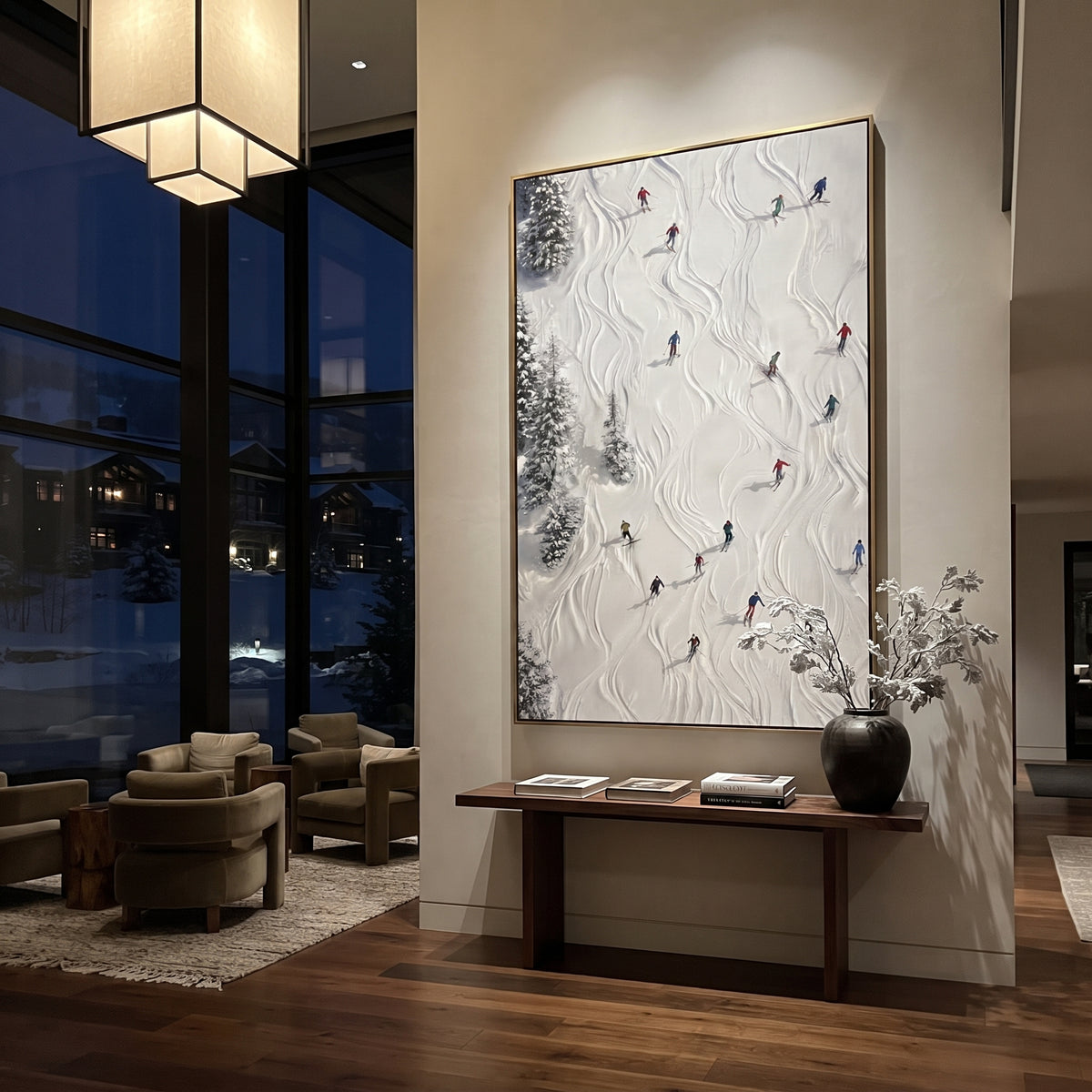 Alpine Pine Slope With Pine Shadows focuses on distant peaks, white powder banks, and raised palette-knife terrain. The artwork shows a winter ski scene built from the actual image: visible downhill figures, curved snow tracks, raised ridgelines, and alpine space arranged in a tall composition. The white, gray, blue palette gives the piece a cold mountain atmosphere while the thick impasto surface creates shadows along each snowbank, ski line, and textured ridge. This is presented as