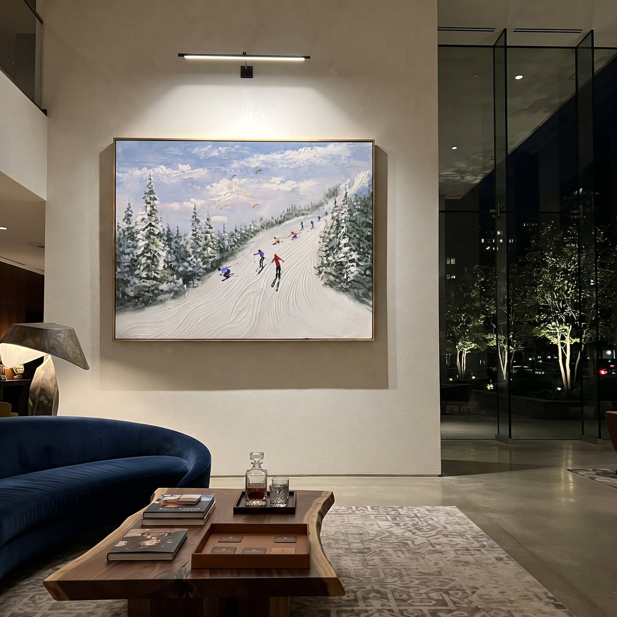 Green Pine Resort Run focuses on skiers descending a pale resort run bordered by green pines and distant mountains. The artwork shows a winter ski scene built from the actual image: visible downhill figures, curved snow tracks, raised ridgelines, and alpine space arranged in a wide composition. The green, white, blue palette gives the piece a cold mountain atmosphere while the thick impasto surface creates shadows along each snowbank, ski line, and textured ridge. This is presented as