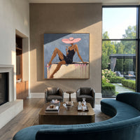 Pink Hat Blue Lounge Figure focuses on seated woman in black dress with long legs, pink wide hat, blue wall, pale sofa ledge, and pink drip marks. The composition is built from the exact pose, clothing shape, accessories, furniture, animal form, shoreline, palm shape, surfboard, or table arrangement visible in this artwork, so the image reads as a specific modern figurative painting rather than a generic decorative abstract. The blue; pink; black palette gives the piece its main atmosphere